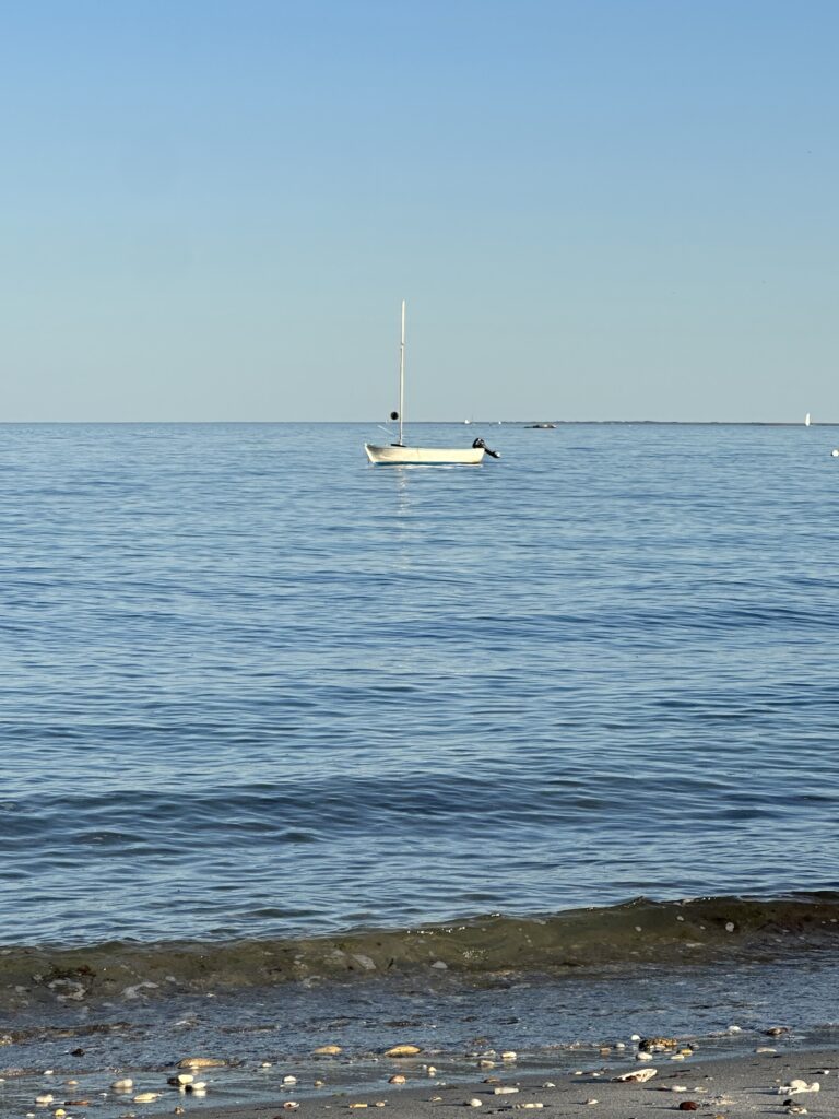 Petit bateau au mouillage sur l'eau calme de la plage du Petit Rohu à Saint-Pierre-Quiberon